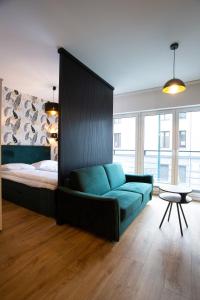 克拉科夫Sunny Apartment Lwowska 10的一间卧室配有一张床和一张蓝色的沙发