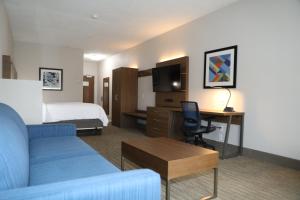 阿尔伯克基阿尔伯克基机场智选假日套房酒店 的酒店客房配有一张床、一张沙发和一张书桌。