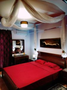 斯巴达Thira Apartment near Athens Airport的一间卧室配有红色的床和镜子
