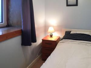 塔伯特Tigh Mairi的一间卧室配有一张床和一张带台灯的桌子
