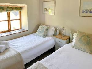 佩恩顿庞德之家乡村别墅的一间卧室设有两张床和窗户。