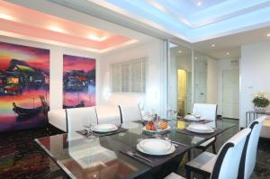芭东海滩PATONG TOWER FAMILY SEA VIEW by PTA的一间带桌子和白色椅子的用餐室