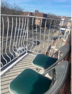 CoronaDouble-Mirrored Glass Room in Queens的阳台配有两把椅子,享有停车场的景致