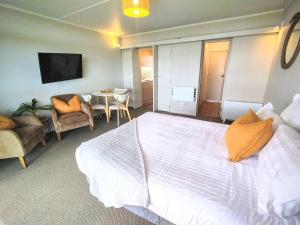 吉斯伯恩花落金沙海滨汽车旅馆 的一间卧室配有一张大床和一张桌子及椅子