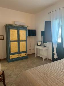 瓦雷多利亚La Casa di Spinosella的一间卧室配有一张床、一个橱柜和一张桌子