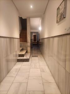马德里HABITACION EN CHUECA, CENTRO DE MADRID的走廊,位于一栋铺有瓷砖地板的建筑内