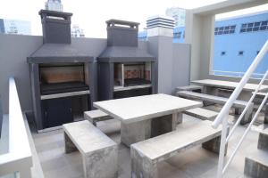布宜诺斯艾利斯Montañeses 2830 Duplex Flat的庭院设有桌子、长凳和壁炉。
