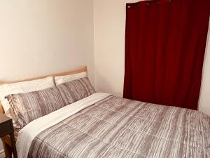 多伦多ComfyRoom的一间卧室配有床和红色窗帘