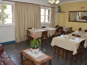丰沙尔彭邵道夫酒店的用餐室设有桌椅和窗户。