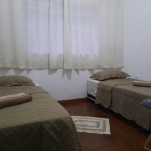 尤西德福拉POUSADA DO JOAO的一间卧室设有两张床,窗户配有窗帘