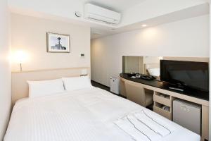 横滨相铁FRESA INN-横滨樱木町(Sotetsu Fresa Inn Yokohama Sakuragi-Cho) 的卧室配有一张白色大床和电视。