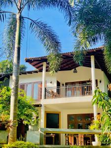 达瓦拉维玛莎拉萨法里之家旅馆的带阳台和棕榈树的房子