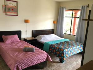 La GaritaVillas el Cenizaro的一间卧室设有两张床和窗户。