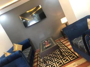JhelumLux Aparts Jhelum的客厅配有2张蓝色沙发和电视