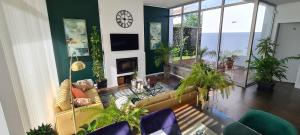 大里贝拉Magnolia Residence - In the Center of the Island的带沙发和植物的客厅以及时钟