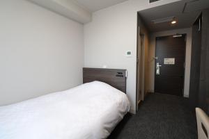 饭田市Silk Hotel的卧室配有白色的床和门
