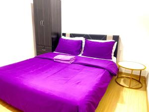 巴生Wallaway2stay Gravit8 Klang 2 Plus 1Room的一张大床,带紫色床单