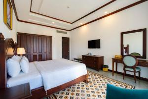 富国Tahiti Resort的一间卧室配有一张床、一张书桌和一面镜子