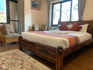 加德满都Hotel Ramanam的一间卧室配有一张大床和一把椅子
