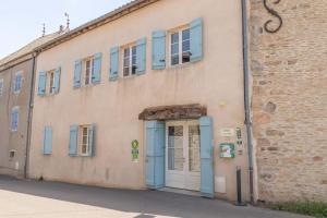 伊热Cabana & Le Gîte de Domange - Proche Mâcon的街道上设有蓝色门窗的建筑