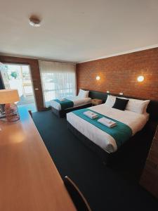 莫阿马莫亚马汽车旅馆的一间卧室设有两张床和砖墙