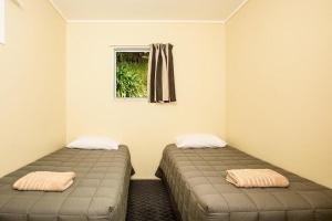 奥波蒂基Tasman Holiday Parks - Ohiwa的带窗户的客房内的两张床