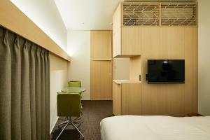 京都HOTEL KYOTOLOGY的配有一张床和一台平面电视的酒店客房