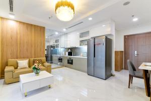 胡志明市Landmark 81 Vinhomes Central Park Luxury Apartment的厨房以及带沙发和冰箱的客厅。