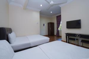 班吉Super OYO 90009 Bangi Sri Minang Guesthouse的酒店客房设有两张床和一台平面电视。