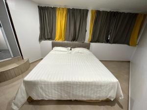 士毛月Hotel Uptown Semenyih的带2扇窗户的客房内的一张白色床