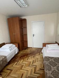 基希讷乌扎雷亚酒店的一间设有两张床和白色门的房间