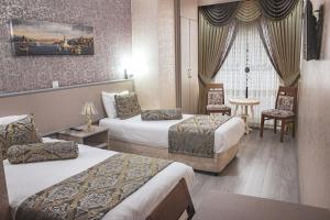伊斯坦布尔马尔马拉冈格林精英酒店的酒店客房带两张床和一张桌子以及椅子。