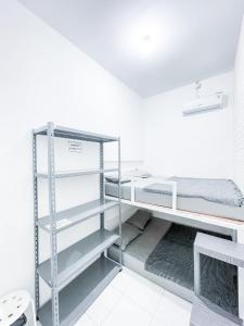 TimuranStay Hub的白色的客房设有双层床和架子