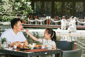 深圳深圳华侨城洲际大酒店的坐在桌子上吃食物的男人和小女孩