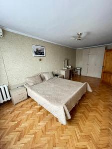 基希讷乌扎雷亚酒店的一间卧室设有一张大床,铺有木地板