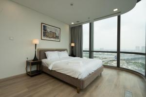 胡志明市Landmark 81 Vinhomes Central Park Luxury Apartment的一间卧室设有一张大床和大窗户