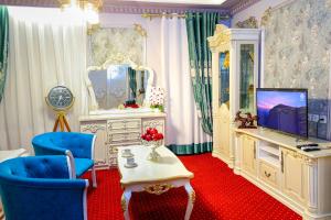 布哈拉Dendi Plaza Hotel的客厅配有电视和蓝椅