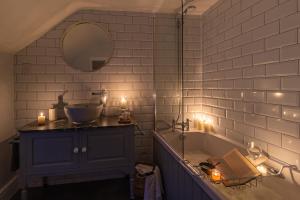 斯卡伯勒Garth Cottage in West Ayton的带浴缸、水槽和蜡烛的浴室