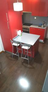 马德里Ático,loft ,duplex的厨房配有红色橱柜和白色的桌椅