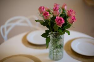 拉奎拉Dimora del Sole - Intero Appartamento的一张桌子上装满粉红色玫瑰的花瓶