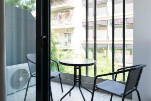 雅典Voda Luxury Residence #202的阳台配有桌椅和窗户