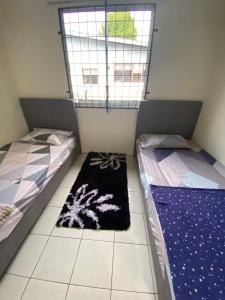 D’Surati River View Homestay的配有窗户和地毯的客房内的两张床