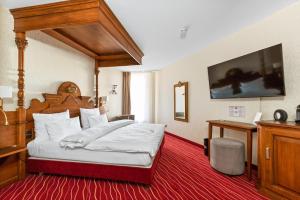 慕尼黑KING's Hotel First的一间卧室配有一张带木制天篷的大床