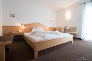 阿皮亚诺苏拉斯特拉达Kreuzstein Bed&Breakfast的一间卧室配有一张带白色床单的大床