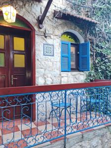 罗什平纳וילה תהילה המחודש - The new Villa Tehila的带阳台的房屋,配有蓝色门和椅子