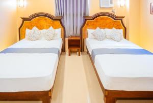 圣何塞RedDoorz Plus @ Hotel Platinum Occidental Mindoro的配有两张床的酒店客房中的两张床
