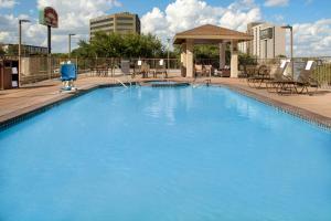 圣安东尼奥圣安东尼奥机场驻桥套房假日酒店的一个带椅子和凉亭的大型蓝色游泳池
