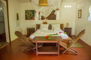 Ile aux NattesAnalatsara Eco Lodge的卧室配有一张床和一张桌子及椅子