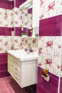 大特尔诺沃KRISSTY Apartment的浴室配有水槽和紫色及白色壁纸。