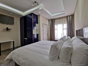 LusikisikiKwaNomzi Botique Lodge的卧室配有带白色枕头的大床